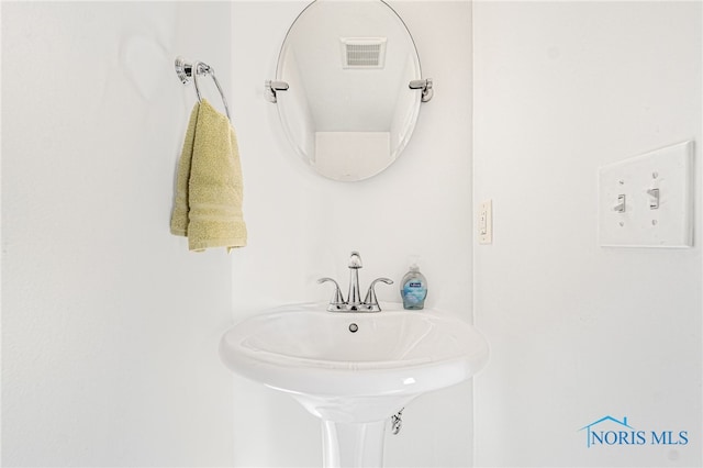 bathroom featuring visible vents and a sink