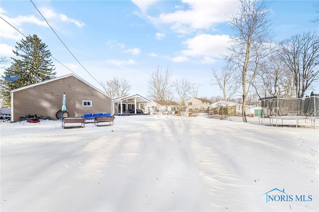 snowy yard with a trampoline