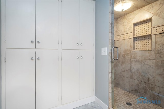 bathroom featuring a shower with door