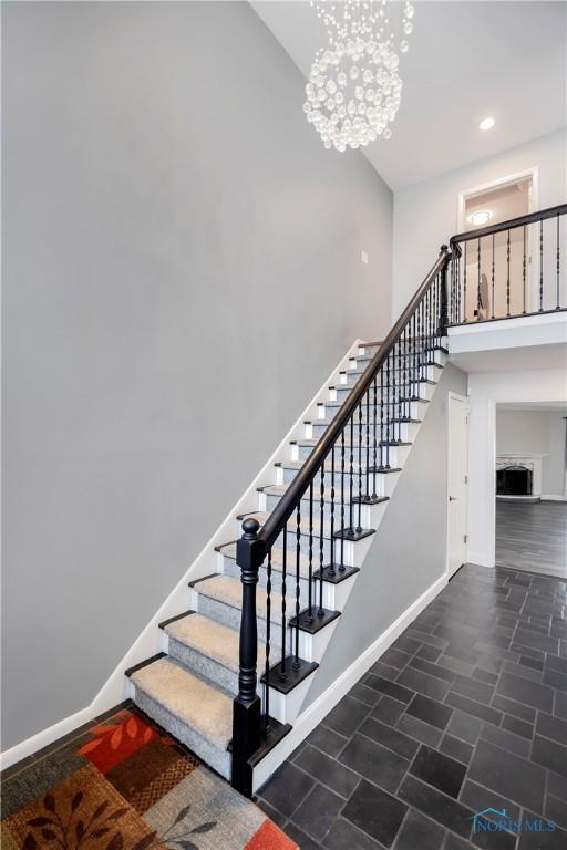 staircase featuring a notable chandelier and a high ceiling