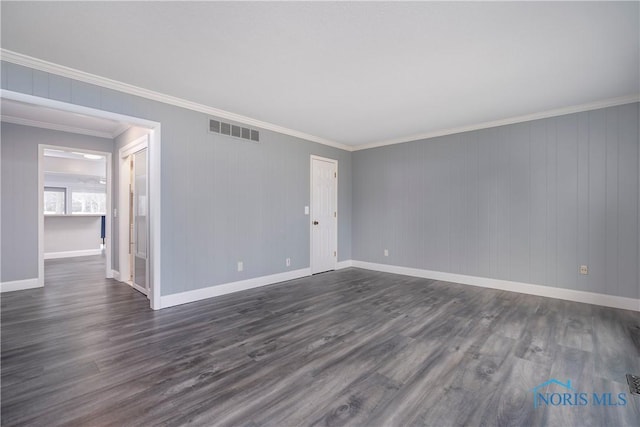 spare room with ornamental molding and dark hardwood / wood-style flooring