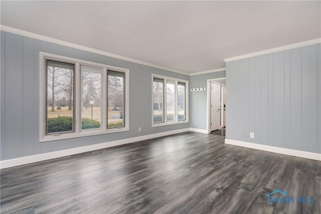 empty room with crown molding and dark hardwood / wood-style flooring