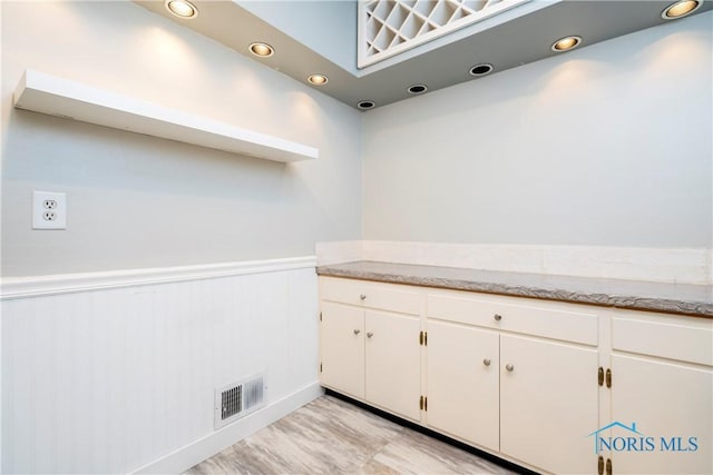 kitchen with white cabinetry and light hardwood / wood-style floors