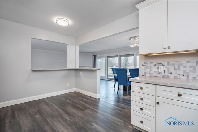 kitchen with backsplash, dark hardwood / wood-style floors, crown molding, and white cabinets