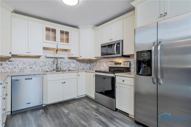 kitchen with sink, dark wood-type flooring, stainless steel appliances, tasteful backsplash, and white cabinets