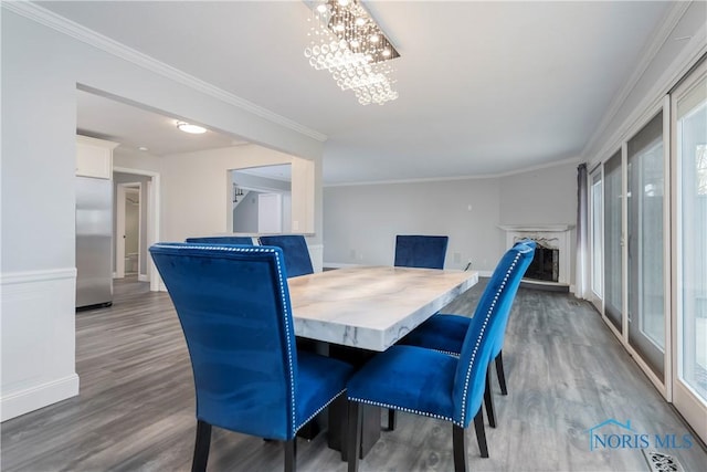 dining room featuring an inviting chandelier, crown molding, and hardwood / wood-style floors