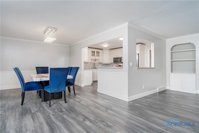 dining area with ornamental molding and dark wood-type flooring