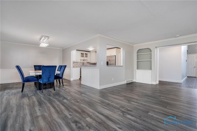 unfurnished dining area featuring crown molding, dark wood-type flooring, and built in features