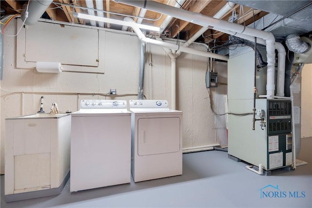 laundry area with washing machine and dryer and heating unit