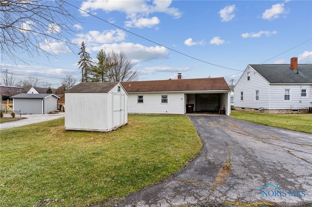 view of front facade featuring a storage shed and a front lawn