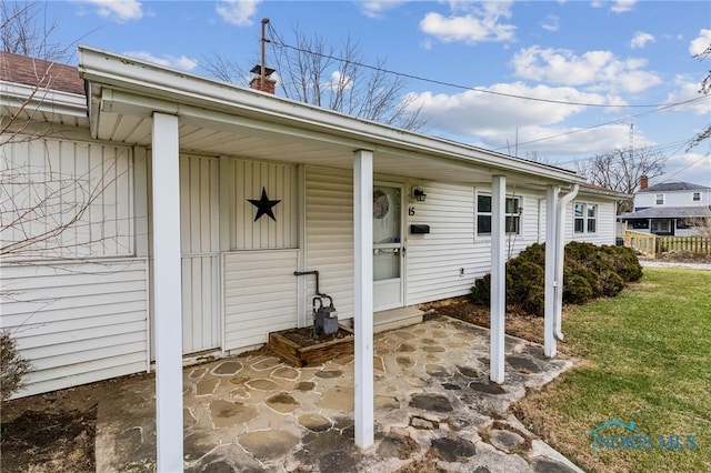 view of exterior entry with a yard