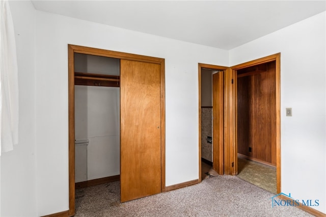 unfurnished bedroom with a closet and carpet flooring