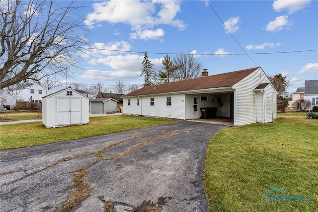 single story home featuring a storage unit and a front yard