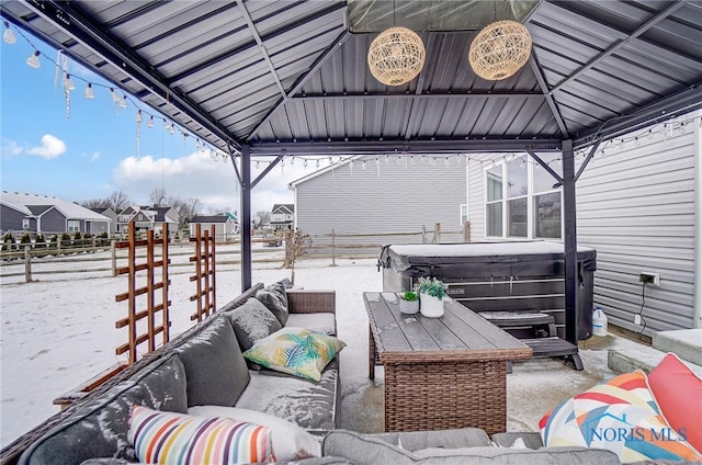 snow covered patio featuring an outdoor living space, a gazebo, and a hot tub