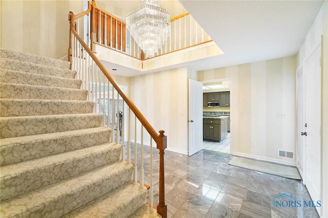 stairs featuring an inviting chandelier