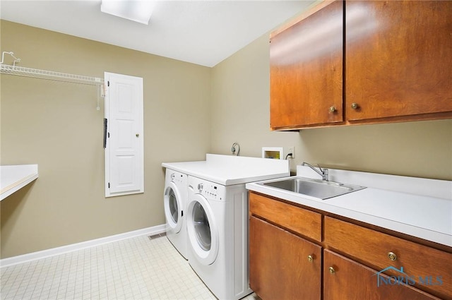 laundry area featuring sink, cabinets, and independent washer and dryer