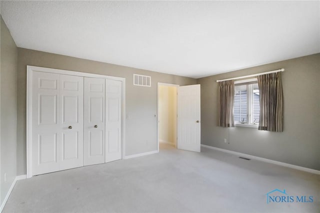 unfurnished bedroom with carpet floors and a closet