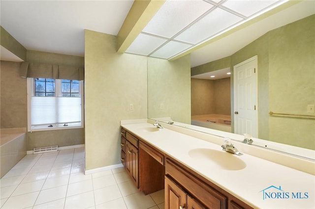 bathroom with a tub to relax in, tile patterned flooring, and vanity