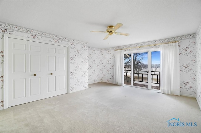 unfurnished bedroom featuring ceiling fan, access to exterior, and light carpet