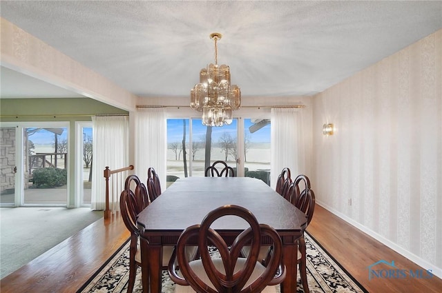 dining space featuring an inviting chandelier, a textured ceiling, and hardwood / wood-style flooring