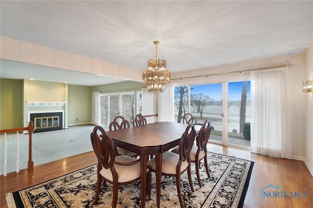 dining area with hardwood / wood-style floors, a notable chandelier, and a textured ceiling