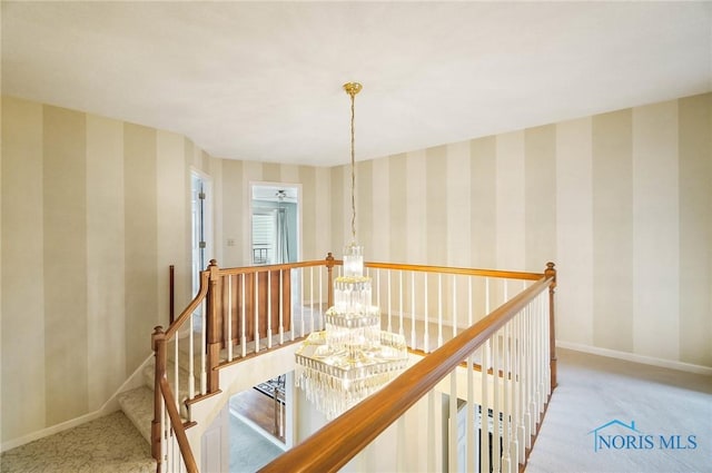 hall featuring light colored carpet and a notable chandelier