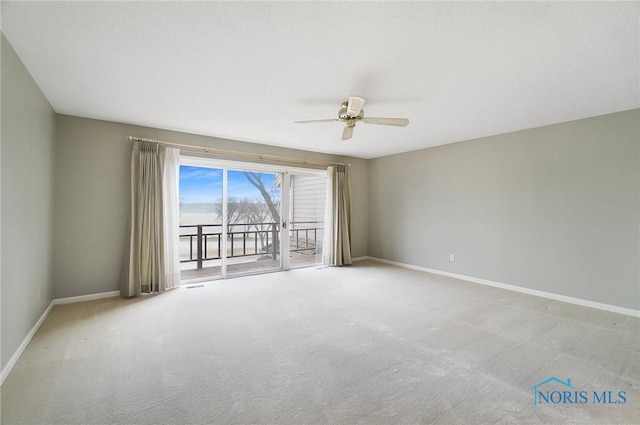 carpeted spare room featuring ceiling fan