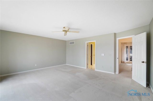 empty room with ceiling fan and light carpet