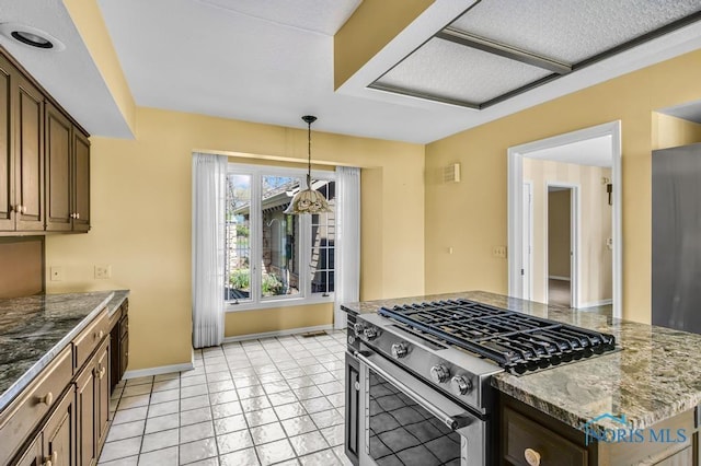 3865 River Rd, Toledo, OH 43614 - kitchen with decorative light fixtures, baseboards, dark stone counters, and stainless steel gas stove