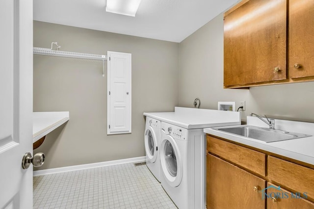 3865 River Rd, Toledo, OH 43614 - washroom with cabinet space, baseboards, a sink, and washing machine and clothes dryer