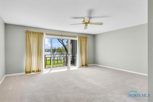 3865 River Rd, Toledo, OH 43614 - carpeted spare room with baseboards, a textured ceiling, ceiling fan, and a water view