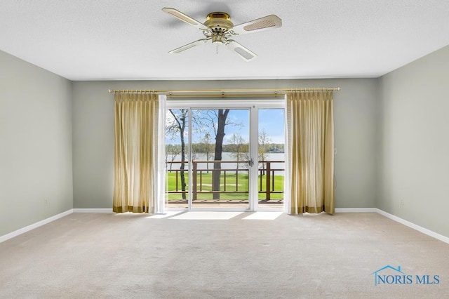 3865 River Rd, Toledo, OH 43614 - carpeted spare room with a water view, baseboards, a ceiling fan, and a textured ceiling