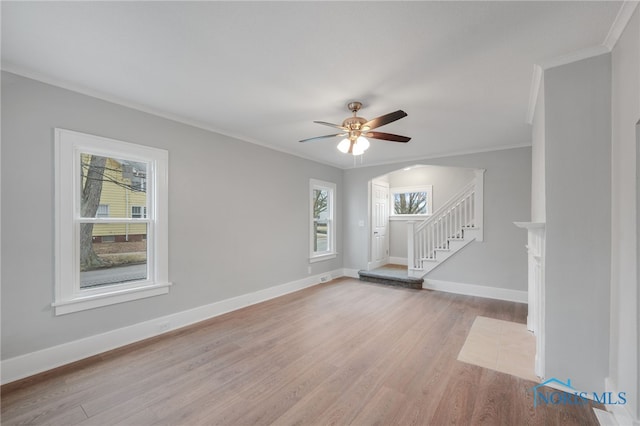 spare room featuring ornamental molding, plenty of natural light, ceiling fan, and light wood-type flooring