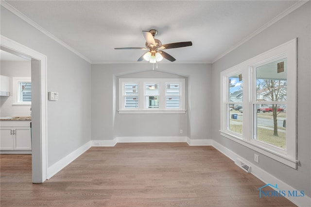 empty room with crown molding, light hardwood / wood-style flooring, and ceiling fan