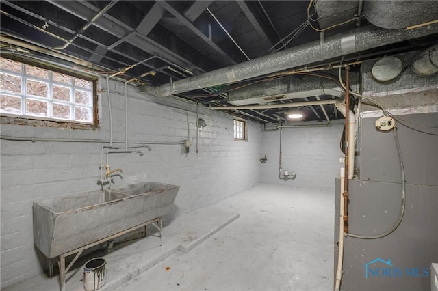 basement with heating unit and sink