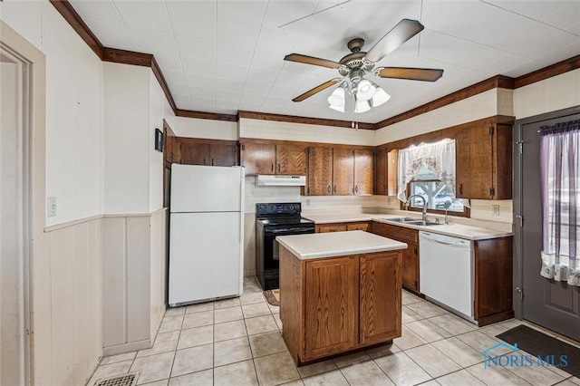 kitchen featuring sink, crown molding, white appliances, light tile patterned floors, and a center island