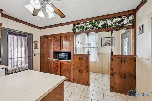 kitchen featuring light tile patterned floors, crown molding, and ceiling fan