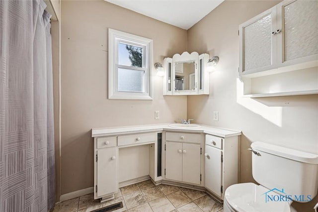 bathroom with vanity, tile patterned flooring, and toilet