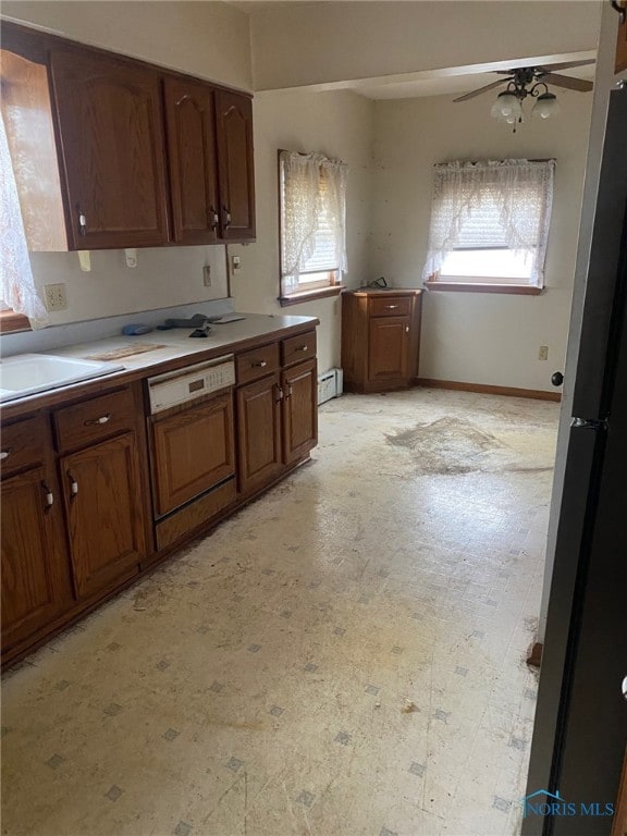 kitchen with ceiling fan, stainless steel fridge, baseboard heating, and plenty of natural light