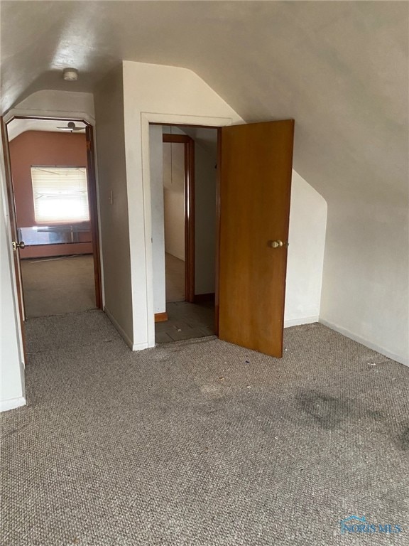 bonus room featuring lofted ceiling and carpet