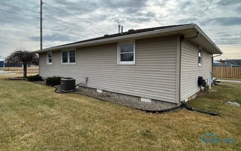 view of property exterior with a yard and central air condition unit