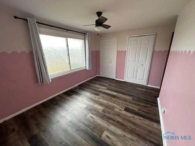 unfurnished bedroom with ceiling fan and dark hardwood / wood-style flooring