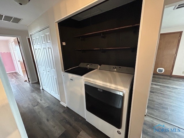 washroom featuring dark hardwood / wood-style floors and washer and clothes dryer