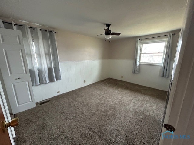 carpeted spare room featuring ceiling fan