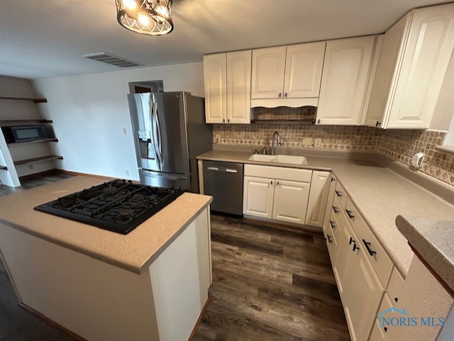 kitchen with tasteful backsplash, sink, black appliances, and white cabinets