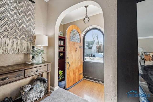 foyer entrance featuring light hardwood / wood-style flooring and ornamental molding