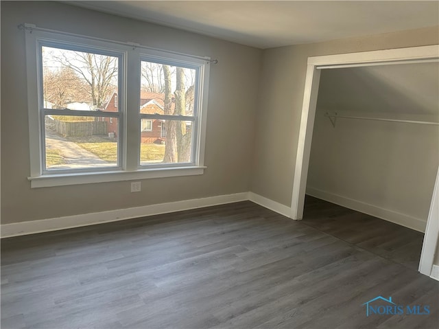 unfurnished bedroom featuring dark hardwood / wood-style floors and a closet