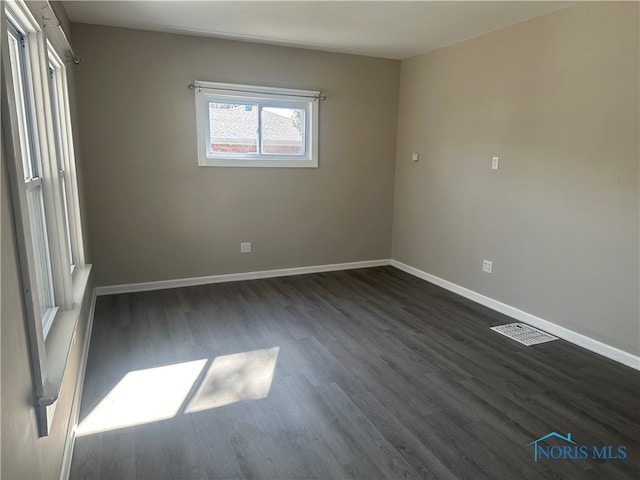 spare room with dark wood-type flooring