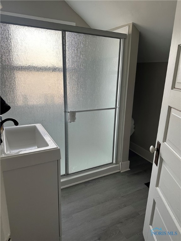 bathroom with lofted ceiling, wood-type flooring, an enclosed shower, and vanity