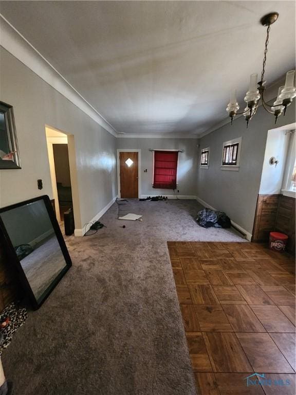 unfurnished living room with ornamental molding and an inviting chandelier